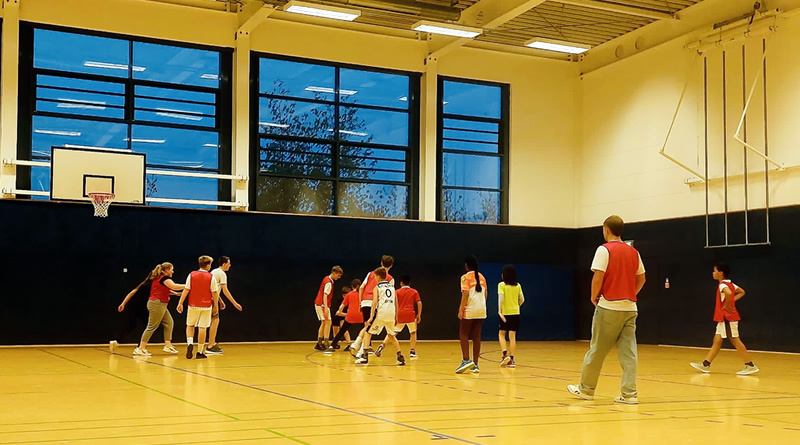 Schülerinnen und Schüler beim gemeinsamen Sport in einer Turnhalle