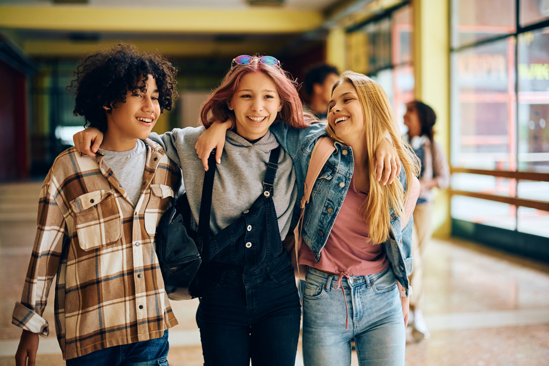 Drei Schülerinnen im Gespräch auf einem Schulflur
